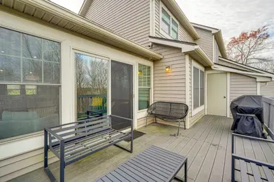a porch with a bench and a chair on a house at Spacious Modern Home about 1 Mi to Camelback Mountain! in Tannersville