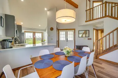a kitchen and dining room with a wooden table and white chairs at Spacious Modern Home about 1 Mi to Camelback Mountain! in Tannersville