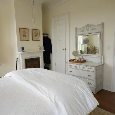 a bedroom with a bed and a dresser and a mirror at Peach Grove House in Warwick