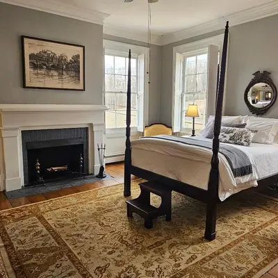 a bedroom with a bed and a fireplace at Peach Grove House in Warwick