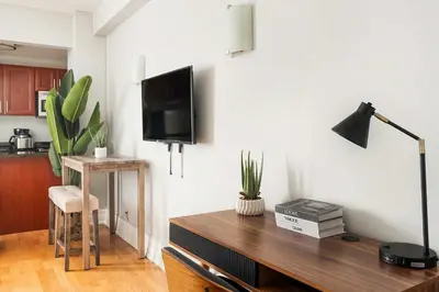 a living room with a desk with a tv on a wall at 73-812 New Studio UWS Doorman Gym in New York