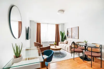 a living room with a couch and a table and chairs at 73-806 New 1BR 1Bth UWS Doorman Gym in New York