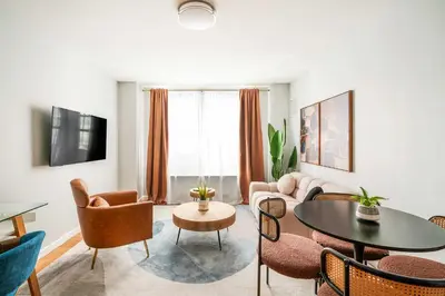 a living room with a couch and a table and chairs at 73-806 New 1BR 1Bth UWS Doorman Gym in New York