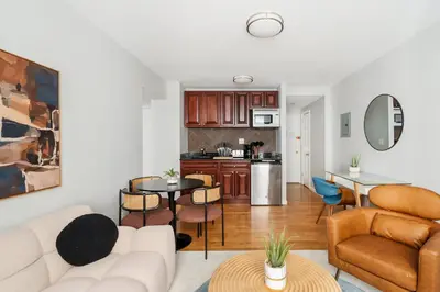 a living room with a white couch and a kitchen at 73-806 New 1BR 1Bth UWS Doorman Gym in New York