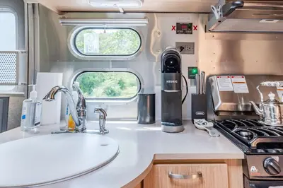 an rv kitchen with a sink and a stove at The Yuzu stunning mountain retreat with hot tub in Gardiner