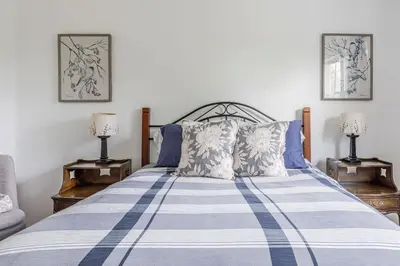 a bedroom with a blue and white striped bed with two lamps at The Yuzu stunning mountain retreat with hot tub in Gardiner