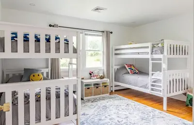 a childs room with white bunk beds and a window at The Yuzu stunning mountain retreat with hot tub in Gardiner