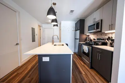 a kitchen with black cabinets and a white counter top at Studio Apartment in the Heart of Philadelphia in Philadelphia