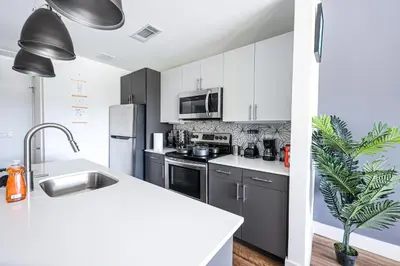 a kitchen with black and white appliances and a sink at StudioAprt QueenBed,WiFi,WD,Parking,Gym in Philadelphia