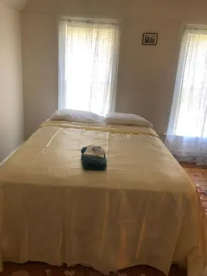 a large bed in a room with two windows at Home Support And Care LLC in Binghamton
