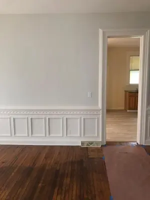 an empty living room with white walls and wood floors at Home Support And Care LLC in Binghamton