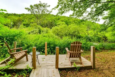 two chairs and a table on a wooden deck at Mtn-View Deck and Grill Creekside Catskills Cabin! in Equinunk