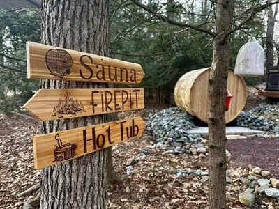 a sign on a tree in front of a hot tub at Lakehouse with Boats, MiniGolf, Sauna, HotTub, Swings and Playground! in Pocono Summit
