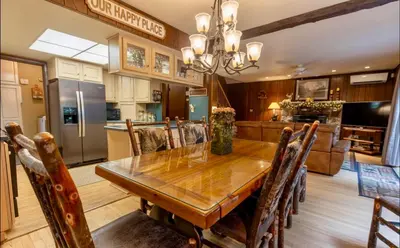 a kitchen and dining room with a wooden table and chairs at Lakehouse with Boats, MiniGolf, Sauna, HotTub, Swings and Playground! in Pocono Summit