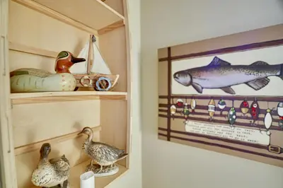 a room with a shelf with ducks and a picture of a fish at Lakehouse with Boats, MiniGolf, Sauna, HotTub, Swings and Playground! in Pocono Summit
