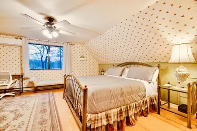 a bedroom with a bed and a ceiling fan at Lakehouse with Boats, MiniGolf, Sauna, HotTub, Swings and Playground! in Pocono Summit