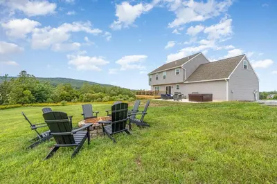 a group of chairs sitting in a field with a house at 10 Acre Hidden Gem in Dillsburg