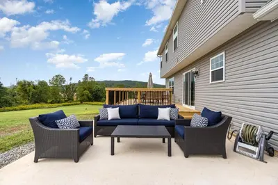 a patio with two chairs and a blue couch at 10 Acre Hidden Gem in Dillsburg