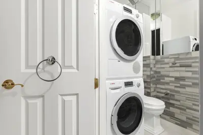 a bathroom with a washer and dryer next to a toilet at Blueground Nolita wd ac nr Little Italy NYC-1570 in New York