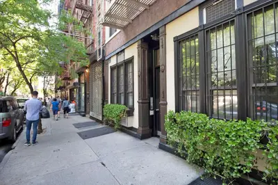a man walking down a sidewalk next to a building at Blueground Nolita wd ac nr Little Italy NYC-1570 in New York