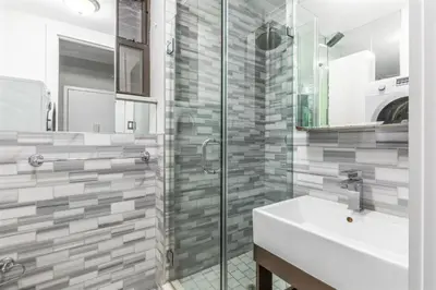 a bathroom with a sink and a glass shower at Blueground Nolita wd ac nr Little Italy NYC-1570 in New York