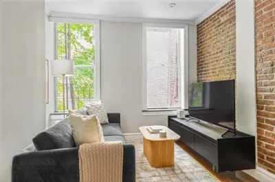 a living room with a couch and a tv at Blueground Nolita wd ac nr Little Italy NYC-1570 in New York