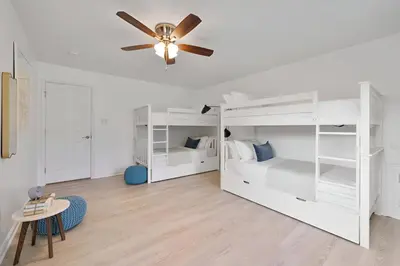 a bedroom with white bunk beds and a ceiling fan at Peaceful Paradise , Dream Holiday Home in Woodridge in Mountain Dale