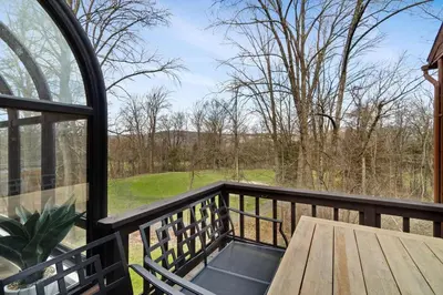 a screened porch with a wooden table and a window at Mountain Creek Townhouse in Vernon Township