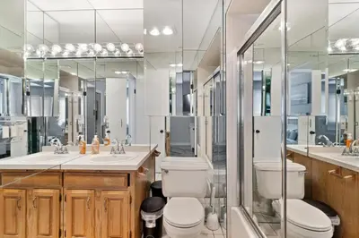 a bathroom with a toilet and a sink and mirrors at Mountain Creek Townhouse in Vernon Township