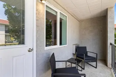 a porch with chairs and a table and a door at The Luxe Nook, Premier Studio in Scenic Congers in Congers