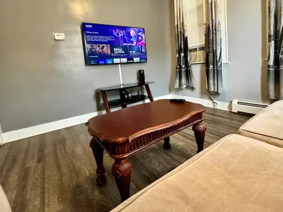 a living room with a coffee table and a tv at Cozy 1 BR, walk to subway, Free WiFi & Parking in Belleville