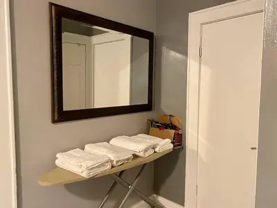 a bathroom with a shelf with towels and a mirror at Cozy 1 BR, walk to subway, Free WiFi & Parking in Belleville