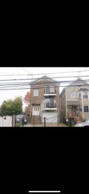 a large house with a fence in front of it at Stylish Urban Getaway 3BR 2BA Patio Oasis Near NYC, EWR & American Dream Mall in Newark