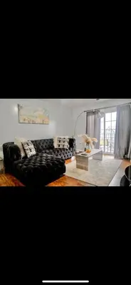 a living room with a couch and a table at Stylish Urban Getaway 3BR 2BA Patio Oasis Near NYC, EWR & American Dream Mall in Newark