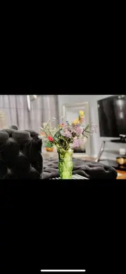 a vase filled with flowers sitting on a table at Stylish Urban Getaway 3BR 2BA Patio Oasis Near NYC, EWR & American Dream Mall in Newark