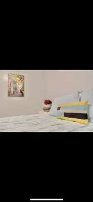 a bedroom with a bed with a painting on the wall at Stylish Urban Getaway 3BR 2BA Patio Oasis Near NYC, EWR & American Dream Mall in Newark