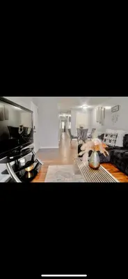 a living room with a couch and a table at Stylish Urban Getaway 3BR 2BA Patio Oasis Near NYC, EWR & American Dream Mall in Newark