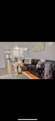 a living room with a couch and a table at Stylish Urban Getaway 3BR 2BA Patio Oasis Near NYC, EWR & American Dream Mall in Newark