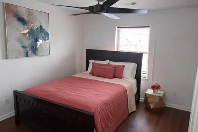 a bedroom with a bed with a red blanket and a ceiling fan at Tremont Hidden Treasure in East Orange