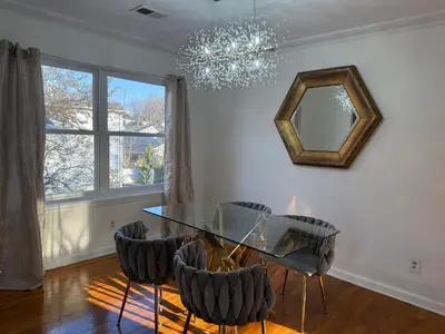a dining room with a glass table and chairs at Tremont Hidden Treasure in East Orange