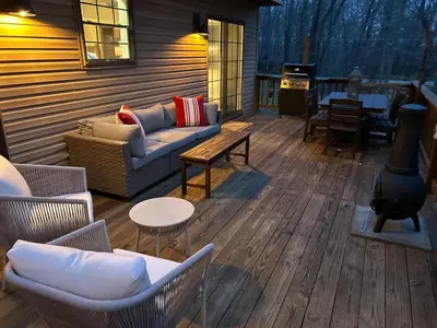 a deck with a couch and chairs and a stove at EVPg in Lehigh
