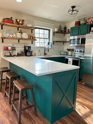 a kitchen with green cabinets and a large blue island at EVPg in Lehigh