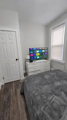 a bedroom with a bed and a flat screen tv at Serenity Haven in Irvington