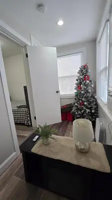 a living room with a christmas tree and a table at Serenity Haven in Irvington