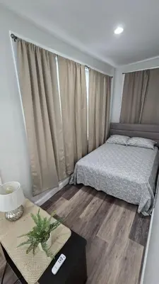 a bedroom with a bed and a table with a night stand at Serenity Haven in Irvington