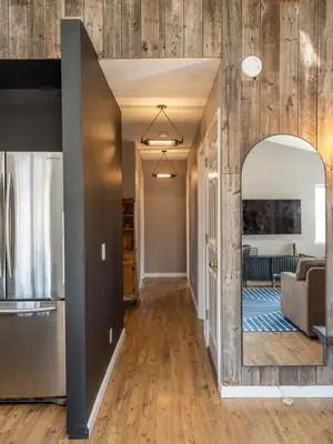 an open living room with a large mirror and wood walls at Private Cabin with Guesthouse Hot Tub Fire Pits in Roscoe