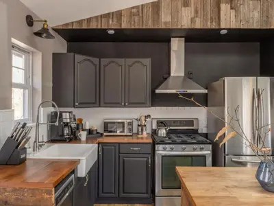 a kitchen with gray cabinets and a stove top oven at Private Cabin with Guesthouse Hot Tub Fire Pits in Roscoe