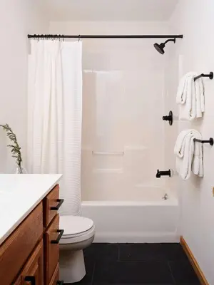 a white bathroom with a shower and a toilet at Private Chalet with Fire Pit Deck and Large Yard in Roscoe