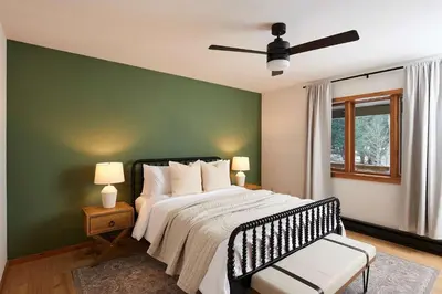 a bedroom with a bed and a green wall at Private Chalet with Fire Pit Deck and Large Yard in Roscoe