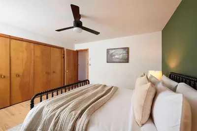 a bedroom with a bed with a ceiling fan at Private Chalet with Fire Pit Deck and Large Yard in Roscoe